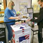 Angi Klahn, left, Clallam County Auditor's Office accountant, helped process voter registration Friday for Seth Russell, formerly of Santa Cruz, Calif., who recently moved to Port Angeles with his partner and her brother. (Paul Gottlieb/Peninsula Daily News)