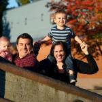 Parents Joelle and Ryan Wheatley pose with their children Anna, 9 months, and Jacob, 2, for a photo, Wednesday, Oct. 21, 2020, in Seattle. As with other families, they are dealing with stricter daycare rules on possible coronavirus symptoms that feel incompatible with the germy reality of modern childhood, where a toddler's sniffle or cough could bring 10 days of quarantine. (AP Photo/Elaine Thompson)