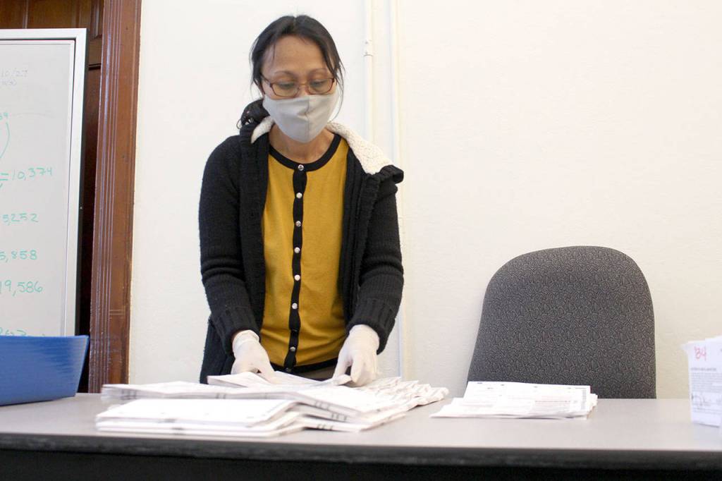 Noeme Riddle, Jefferson County fiscal coordinator specialist, works to flatten ballots Tuesday, Nov. 3, 2020, before they are run through the tabulation machine. (Zach Jablonski/Peninsula Daily News)