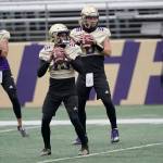 Washington quarterbacks Jaden Sheffey, center, Kevin Thomson, left, and Jacob Sirmon, right, pass in a group during NCAA college football practice Friday, Oct. 16, 2020, in Seattle. (Ted S. Warren/Associated Press)