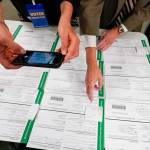 A canvas observer photographs Lehigh County provisional ballots as vote counting in the general election continued Friday, Nov. 6, 2020, in Allentown, Pa. (Mary Altaffer/Associated Press)
