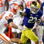 Notre Dame running back Kyren Williams (23) fends off Clemson Tigers safety Nolan Turner (24) on his way to a touchdown Saturday, Nov. 7, 2020, in South Bend, Ind. (Matt Cashore/Pool Photo via AP)