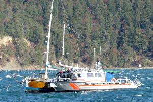 East Jefferson Fire Rescue personnel reach a man and his dog aboard a sailboat after the vessel's mast broke on Sunday. (East Jefferson Fire Rescue)