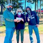 From left, Lincoln Park BMX Track operator Sean Coleman, Marsha Robin and Jason Groves show a check for $2,149 raised by the BMX track and riders fro the Port Angeles Food Bank for hte month of October. The track and riders also raised 360 pounds of food. The top earners were Bennett and Bradan Gray, first place, George Williams, second place and Cholena Morrison, third place.