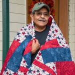 Daniel J. Merino, U.S. Army veteran, is wrapped in the quilt that was recently made for and presented to him by the North Olympic Peninsula Quilts of Valor group. (Photo courtesy of Christopher Bates Photography)