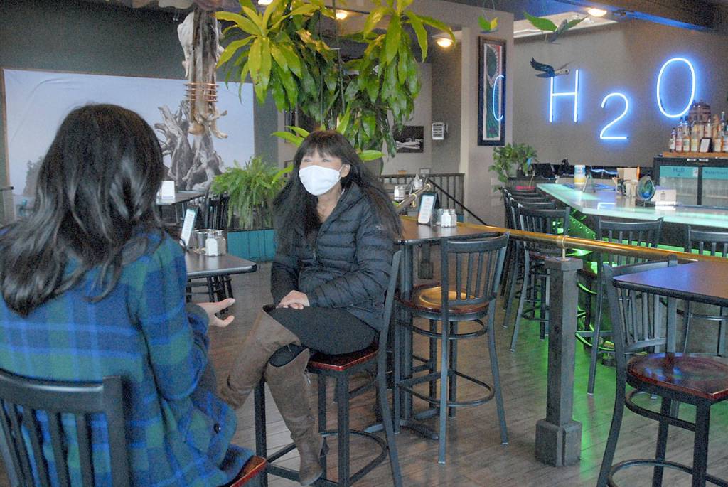 Young Johnson, owner of H2O on the Port Angeles waterfront, chats during an interview with ABC News correspondent Zohreen Shah during an interview on Friday for an upcoming televisiion segment. (Keith Thorpe/Peninsula Daily News)