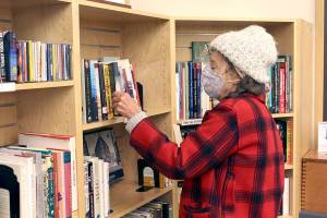 Pama O'Toole of Port Hadlock was in one of her favorite places as she browsed the books at the Jefferson County Library on Friday. The library has been open for in-person book checkout and other rentals when the county is in the state's low- and moderate-risk categories. The library also offers curbside pick and will continue to do so if it is required to close in-person visits due to rising case numbers of COVID-19. The Port Townsend Public Library hopes to open Tuesday with limited hours for checkout, depending on the county staying in the moderate-risk category. (Zach Jablonski/Peninsula Daily News)