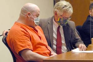 Ryan Warren Ward, left, looks over court papers with attorney Lane Wolfley during Ward's sentencing for three counts of aggravated first-degree murder and multiple counts of theft and firearms violations on Thursday in Clallam County Superior Court in Port Angeles. (Keith Thorpe/Peninsula Daily News)