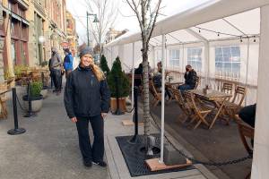 Whiskey Mill, Alchemy and Sirens owner Kris Nelson stand in front of the busy outdoor dining tent at Whiskey Mill on Friday, Nov. 11, 2020,  as lunch patrons dine in the afternoon. Due to reinstated restrictions by Gov. Jay Inslee, restaurants are required to serve food either to go or outdoors. (Zach Jablonski/Peninsula Daily News)