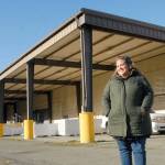 Port Angeles Food Bank Executive Director Emily Dexter stands outside the food banks new warehouse and distribution center at 632 N. Oakridge Drive near the Port Angeles Walmart. The covered canopy area will become the food banks drive-thru distribution lane. (Keith Thorpe/Peninsula Daily News)