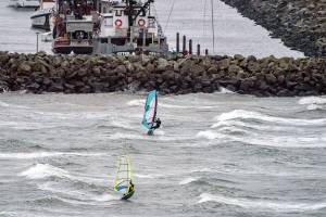 A pair of wind surfers take advantage of the high winds and blast across Port Townsend Bay on Tuesday. Gale force winds created unsafe conditions so the 9:30 Port Townsend-Coupeville ferry run was canceled. Jefferson Public Utility District crews responded to several small outages throughout the day. (Steve Mullensky/for Peninsula Daily News)