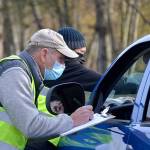Volunteers Steve Allen and Bruce Winters check in a participant of the Family Holiday Meal distribution program. Organizers estimate about 900 families received food packages. (Matthew Nash/Olympic Peninsula News Group)