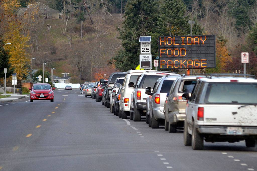 Vehicles lined up throughout a three-hour span to receive free Thanksgiving meals from the Family Holiday Meal Bag distribution program in Carrie Blake Community Park. (Matthew Nash/Olympic Peninsula News Group)