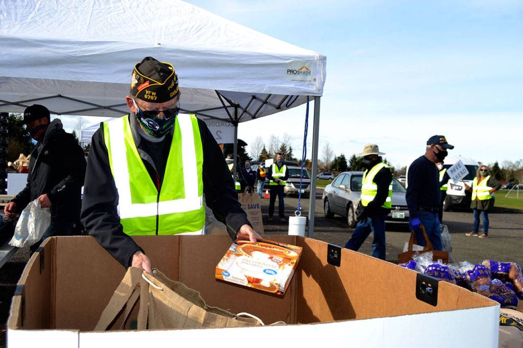 Calvin Barnard, senior vice commander of Carlsborg VFW Post 6787, places a pie in a bag for a family at the Family Holiday Meal Bag distribution. (Matthew Nash/Olympic Peninsula News Group)