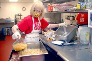 Volunteer Phyllis Meyer of Sequim adds broth to make stuffing for Wednesday's traditional Thanksgiving Eve lunch at the Port Angeles Salvation Army. (Keith Thorpe/Peninsula Daily News)