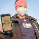 Nurse Jessica Franz, shows a photo of her mother-in-law, Elaine Franz, outside Olathe Medical Center after working the graveyard shift Thursday, Nov. 26, 2020, in Olathe, Kan. Elaine Franz died Nov. 10, one day before her 78th birthday, after contracting COVID-19. (AP Photo/Charlie Riedel)
