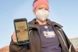 Nurse Jessica Franz, shows a photo of her mother-in-law, Elaine Franz, outside Olathe Medical Center after working the graveyard shift Thursday, Nov. 26, 2020, in Olathe, Kan. Elaine Franz died Nov. 10, one day before her 78th birthday, after contracting COVID-19. (AP Photo/Charlie Riedel)