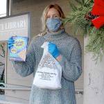 Quintana Kelley, library assistant at the Jefferson County Library, holds the gingerbread house-making kit that the library is passing out for its annual edible house-building competition. Registration to pick up the free kits closes Saturday, and photos of the finished houses are due by Dec. 13. (Zach Jablonski/Peninsula Daily News)