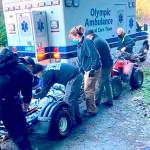An injured biker is treated Saturday by Clallam Fire District No. 2 personnel after being brought down from the backcountry after a wreck. (Photo courtesy of Mike McVaugh)