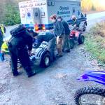 An injured biker is treated Saturday by Clallam Fire District No. 2 personnel after being brought down from the backcountry after a wreck. (Photo courtesy of Mike McVaugh)