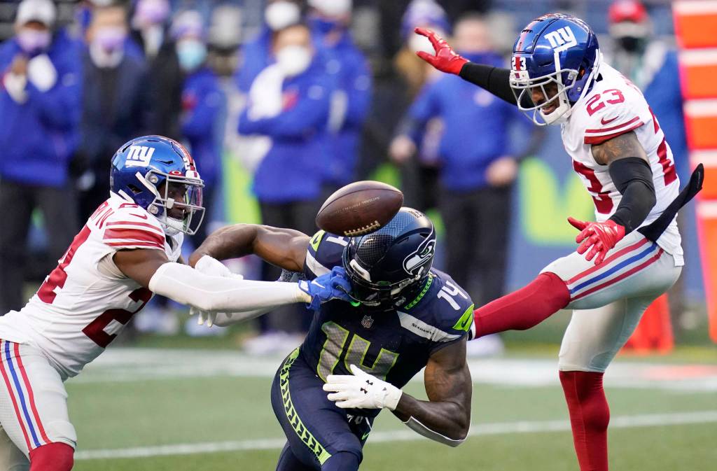 New York Giants cornerback James Bradberry, left, and defensive back Logan Ryan, right, break up a pass intended for Seattle Seahawks wide receiver DK Metcalf (14) during the second half of an NFL football game, Sunday, Dec. 6, 2020, in Seattle. The Giants won 17-12. (AP Photo/Elaine Thompson)