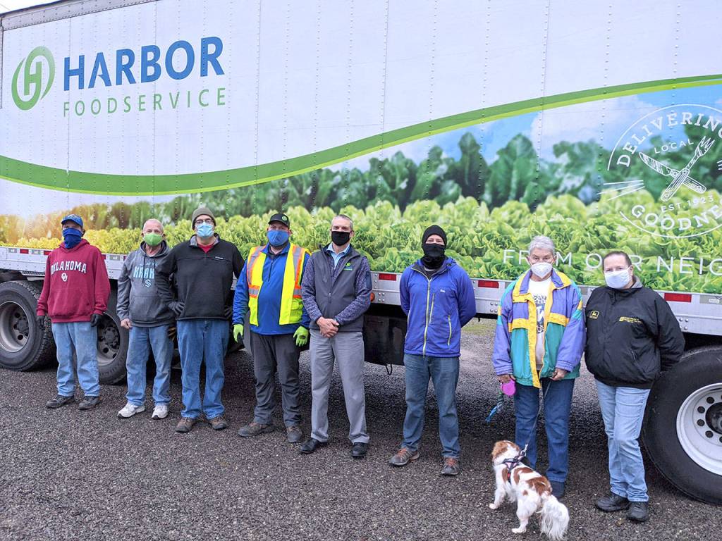 Several volunteers with the Jefferson County Food Bank Association met at the Tri-Area Food Bank on Thursday, Dec. 10, 2020, to unload 533 hams that were purchased at a discount from Harbor Foodservice. Pictured are Tri-Area Food Bank manager John Laird, left, past association president Mike Langenbach, current president Mike Boock, Harbor Foodservice truck driver Elijah Grenot, Harbor Foodservice sales consultant Derek Schmidt, food bank volunteer Chance Worton, Brinnon Food Bank manager Eloise Langenbach and volunteer Kate Sullivan. (Zach Jablonski/Peninsula Daily News)
