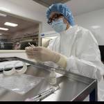 A pharmacist labels syringes in a clean room where doses of COVID-19 vaccines will be handled, Wednesday, Dec. 9, 2020, at Mount Sinai Queens hospital in New York. The hospital expects to receive doses once a vaccine gets the emergency green light by U.S. regulators. (AP Photo/Mark Lennihan)