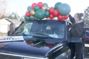 Dave Logan/for Peninsula Daily News
Chelsey Bettger of Joyful Events and Balloons, left, and Katheryn Murray of PNW Mobile Detailing decorate one of the vehicles to be in the Candy Cane Parade of Happiness.