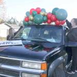 Chelsey Bettger, of Joyful Events and Balloons, left, and Katheryn Murray, of PNW Mobile Detailing, decorate one of the vehicles to be used in the Candy Cane Parade of Happiness. (Dave Logan/for Peninsula Daily News)