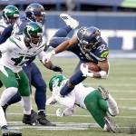 Seattle Seahawks running back Chris Carson (32) is upended on a carry against the New York Jets on Sunday in Seattle. (AP Photo/Lindsey Wasson)