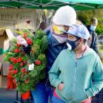 Morgan Hanna, left, and Kenenisa Hanna found a Serendipity Farm wreath at Saturdays Uptown Port Townsend farmers market. The last market of the year is this Saturday from 10 a.m. to 2 p.m. (Diane Urbani de la Paz/Peninsula Daily News)