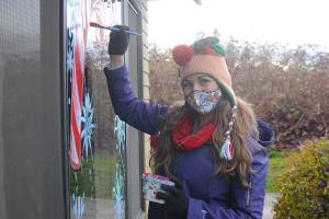 Anya Aubertin, owner-artist of Smells Like Crayons, splashes some festive colors on the windows at Avamere Olympic Rehabilitation of Sequim last week. Michael Dashiell/Olympic Peninsula News Group