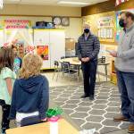 State Rep. Mike Chapman, right, speaks to first-grade students during a Thursday tour of Crescent School in Joyce as school Superintendent Dave Bingham, second from right, looks on. Chapman visited the school to see how the district's hybrid system of in-class and remote instruction was working and to discuss school funding issues. Crescent currently makes in-person instruction available to students in kindergarten through sixth grade with middle and high school students on campus on a two-day-per-week schedule intermixed with remote learning. All parents are given the option of remote instruction for their children. (Keith Thorpe/Peninsula Daily News)