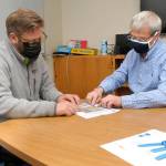 State Rep. Mike Chapman, left, and Crescent School Superintendent Dave Bingham examine enrollment statistics for the school district on Thursday in Joyce. (Keith Thorpe/Peninsula Daily News)