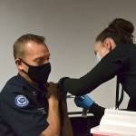 Nurse Kelly Bower with the Jamestown Family Health Clinic gives a Moderna COVID-19 Vaccine to Capt. Derrell Sharp with Clallam County Fire District 3 on Tuesday at the fire station’s headquarters. Clinic leaders say they’ve begun circulating the vaccine to first responders and plan to offer community vaccinations in the coming weeks. (Matthew Nash/Olympic Peninsula News Group)