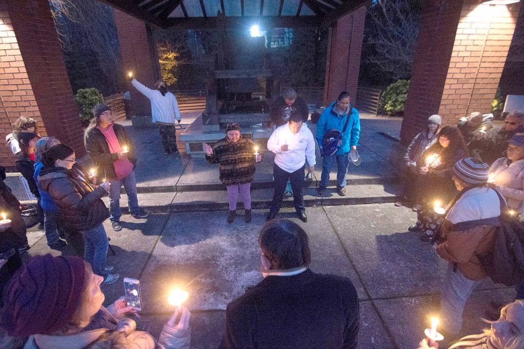 A crowd gathers around Thelma Lawrence and Jonathan Arakawa of the Lower Elwha SKlallam Tribe as they sing during a vigil for Valerie Claplanhoo after she was killed. (Peninsula Daily News file)