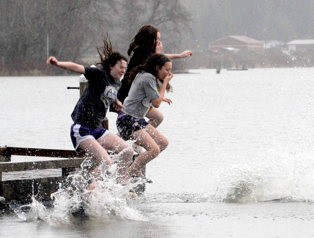 With two teens under water three more dive from the Clallam County Lake Pleasant dock New Years morning. Approximately 25 teens and adults took part in the annual Polar Bear Dip. Most entered the lake from the beach with a few as seen here diving from the dock. (Courtesy Lonnie Archibald.)