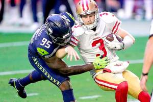 San Francisco 49ers quarterback C.J. Beathard (3) is sacked by Seattle Seahawks defensive end Benson Mayowa (95) during the first half of an NFL football game, Sunday, Jan. 3, 2021, in Glendale, Ariz. (AP Photo/Ross D. Franklin)