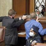 Police with guns drawn watch as protesters try to break into the House Chamber at the U.S. Capitol on Wednesday in Washington, D.C. (J. Scott Applewhite/The Associated Press)