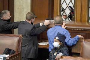 Police with guns drawn watch as protesters try to break into the House Chamber at the U.S. Capitol on Wednesday in Washington, D.C. (J. Scott Applewhite/The Associated Press)