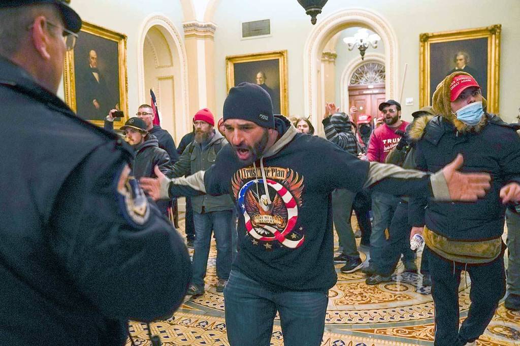 Trump supporters gesture to U.S. Capitol Police in the hallway outside of the Senate chamber on Wednesday at the Capitol in Washington, D.C. (Manuel Balce Ceneta/The Associated Press)