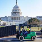 DC National Guard stands outside a mostly quiet Capitol, Thursday morning, Jan. 7, 2021 in Washington, as workers place security fencing in place. The House and Senate certified the Democrat's electoral college win early Thursday after a violent throng of pro-Trump rioters spent hours Wednesday running rampant through the Capitol. A woman was fatally shot, windows were bashed and the mob forced shaken lawmakers and aides to flee the building, shielded by Capitol Police. (AP Photo/John Minchillo)