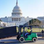 DC National Guard stands outside a mostly quiet Capitol, Thursday morning in Washington, as workers place security fencing in place. The House and Senate certified the Democrats electoral college win early Thursday after a violent throng of pro-Trump rioters spent hours Wednesday running rampant through the Capitol. A woman was fatally shot, windows were bashed and the mob forced shaken lawmakers and aides to flee the building, shielded by Capitol Police. (AP Photo/John Minchillo)