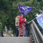 Three people stand and wave flags above morning traffic from a pedestrian overpass near the Capitol in Olympia on Thursday, the day after supporters of President Donald Trump protested in Olympia against the counting of electoral votes in Washington, D.C., to affirm President-elect Joe Bidens victory. (Ted S. Warren/The Associated Press)