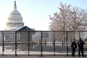 Capitol police officers stand outside of fencing that was installed around the exterior of the Capitol grounds, Thursday, Jan. 7, 2021 in Washington. The House and Senate certified the Democrat's electoral college win early Thursday after a violent throng of pro-Trump rioters spent hours Wednesday running rampant through the Capitol. A woman was fatally shot, windows were bashed and the mob forced shaken lawmakers and aides to flee the building, shielded by Capitol Police. (AP Photo/John Minchillo)