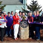 Executive Director Carol Willis, center left, cuts the ribbon for Olympic Theatre Arts new sign Feb. 1, 2020, as part of an open house with theatre supporters and members of the Sequim-Dungeness Valley Chamber of Commerce. Willis stepped down from her OTA role recently with health issues.