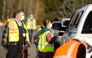 Dr. Molly Martin, deputy medical director at the Jamestown SKlallam Tribe, and Community Emergency Response Team member Jim Johnston help individuals get registered for COVID-19 vaccinations at the tribes clinic on Jan. 14. Sequim Gazette photo by Michael Dashiell