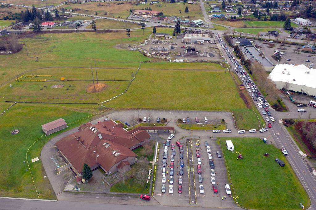 A line of cars stretches back to back to the U.S. Highway 101/Simdars Road exit from the registration site at 100 S. Blake Ave., by about 9:24 a.m. Thursday during Sequims first drive-through vaccination clinic. Some 500 were vaccinated and three times that many were turned away. Another Sequim first-come, first-served clinic was on Saturday and more are planned from 9 a.m.-3 p.m. this coming Thursday and Saturday. (John Gussman)