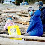 Eowyn Reardon, 22 months, assisted parents Benjamin Reardon and Amy Johnson of Port Townsend at the Martin Luther King Jr. Day beach cleanup on Monday. Scores of people took to the shores at Fort Worden State Park for the event hosted by the Port Townsend Marine Science Center. (Diane Urbani de la Paz/Peninsula Daily News)