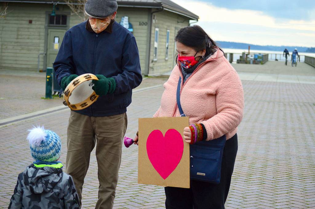 Sara Ybarra Lopez and Mark Stevenson of Port Townsend met Kaspar Kluck, 2 1/2, at downtown Port Townsends Inauguration Day celebration Wednesday afternoon. (Diane Urbani de la Paz/Peninsula Daily News)